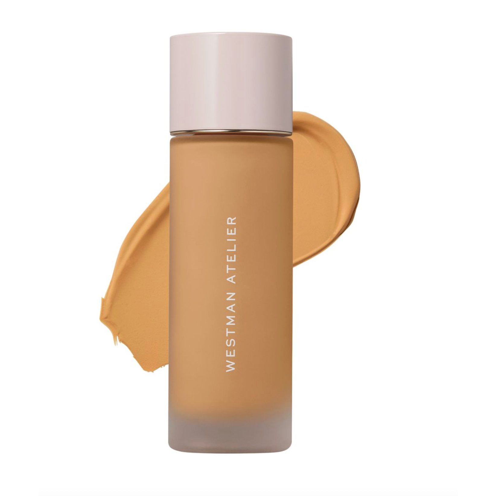 Westman Atelier liquid foundation in a frosted glass bottle with a pale pink cap, shown against a white background with a warm beige foundation swatch behind it.