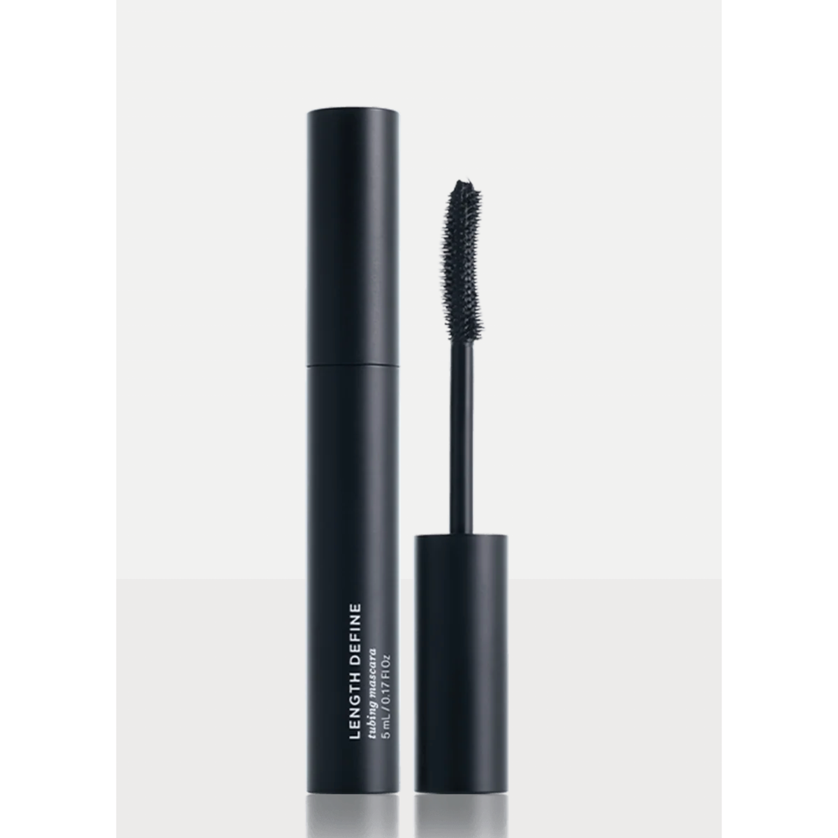Black mascara tube with white text reading LENGTH DEFINE and PRIME LASH ESSENCE, shown beside its wand applicator on a clean light gray background.