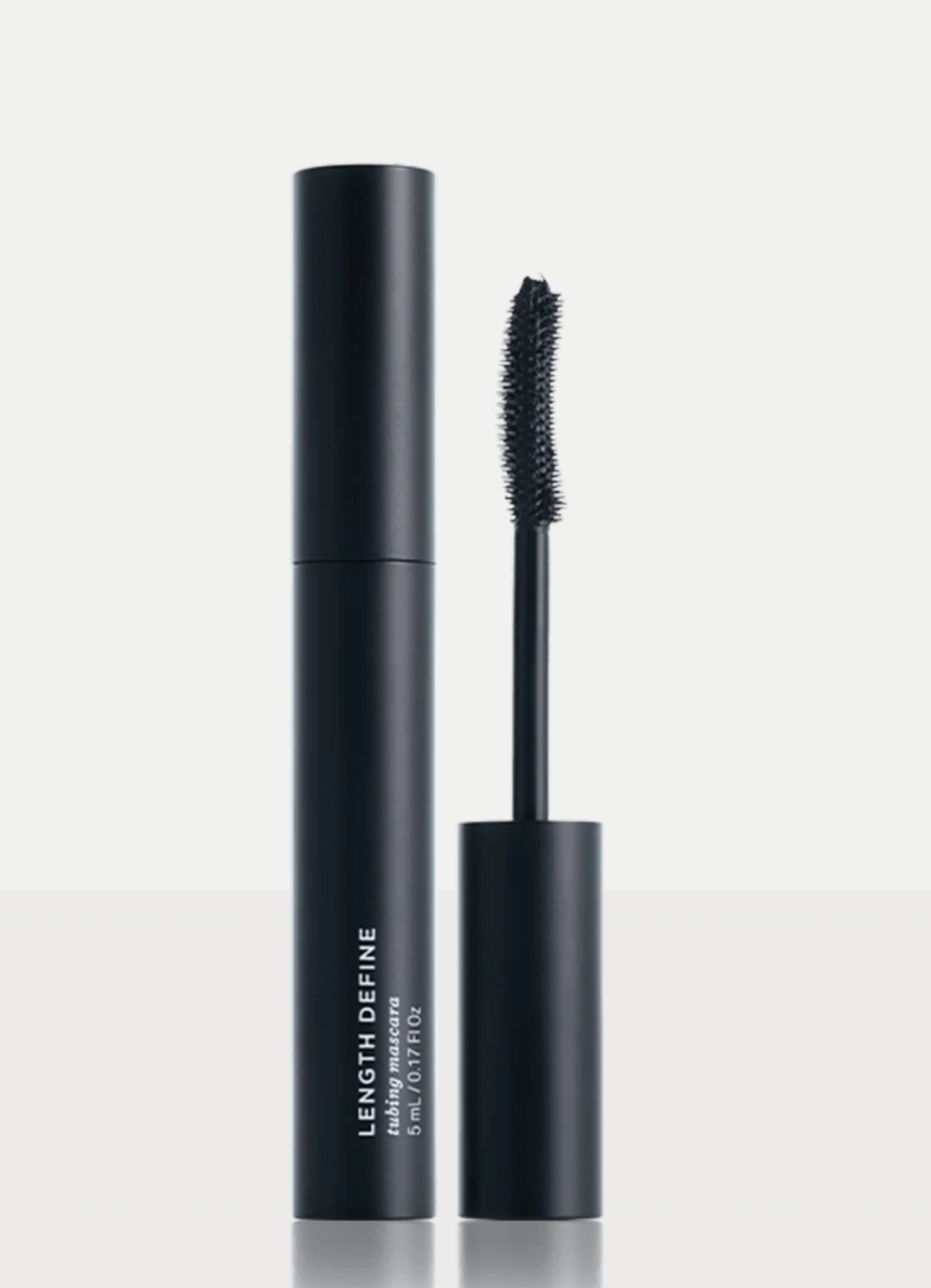 Black mascara tube with white text reading LENGTH DEFINE and PRIME LASH ESSENCE, shown beside its wand applicator on a clean light gray background.